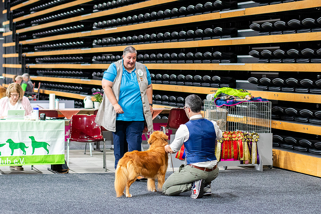 Newton steht vor der Richterin, die sich ihm nähert, Stephan kniet dahinter