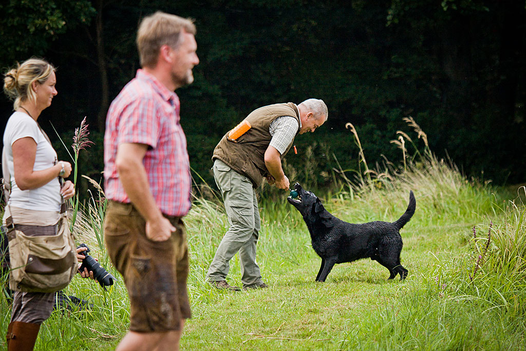 Thomas belohnt Enyo mit einem Zerrspiel, im Vordergrund sind Eva und Carsten zu shen
