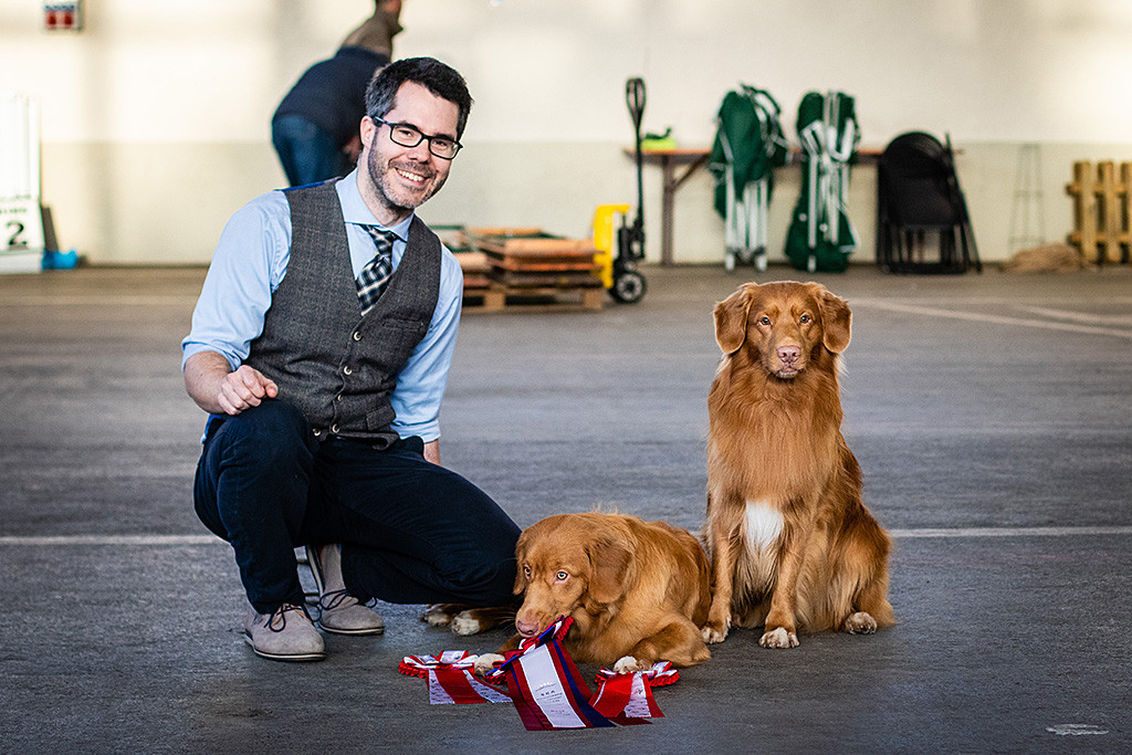 Edison sitzt, Newton liegt und Stephan hockt hinter den auf dem Boden liegenden Gewinnerrosetten