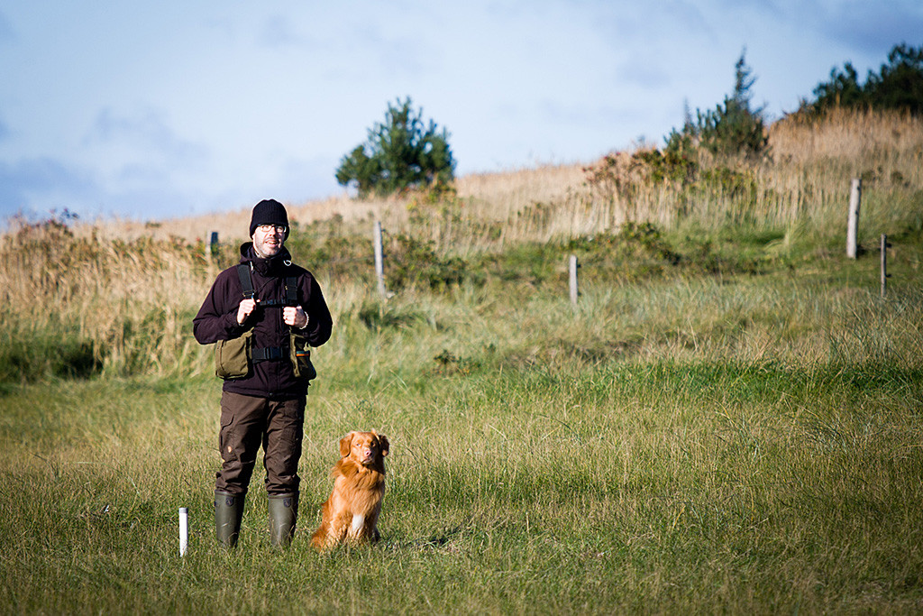Edison sitzt neben Stephan im Gras, beide schauen sich die Aufgabe an