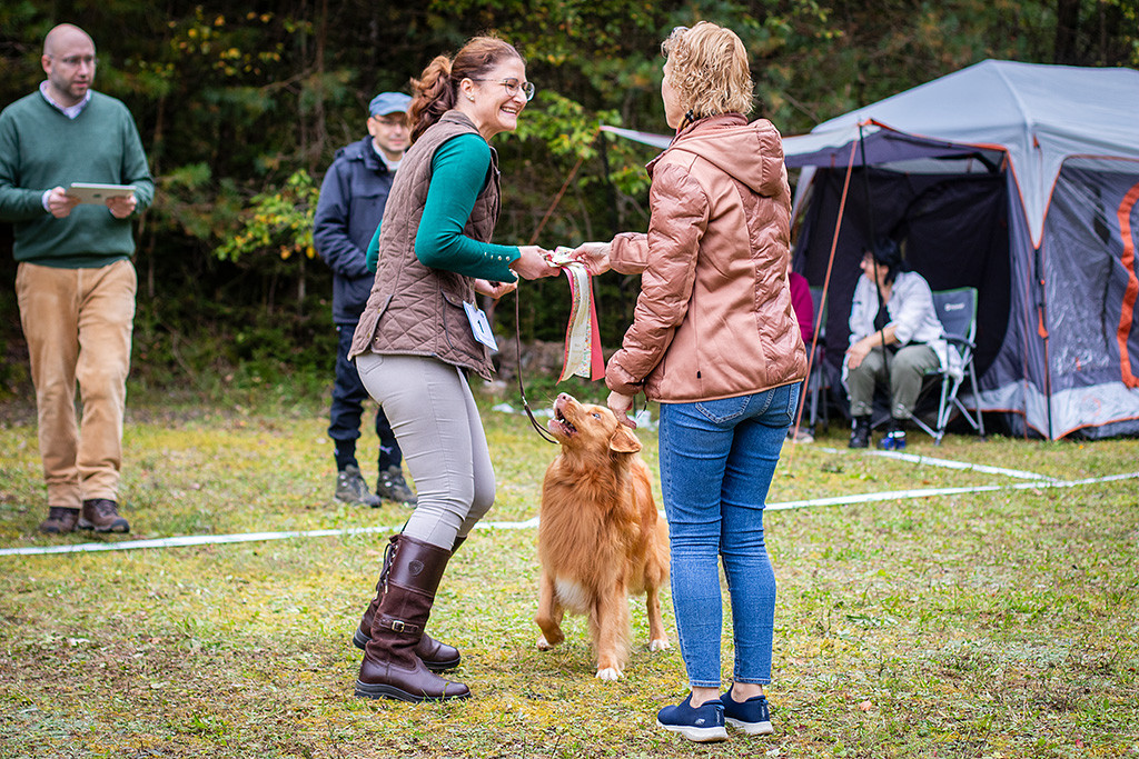 Anika nimmt Edisons Best Veteran Schleife lächelnd von Richterin Kati Heiskanen entgegen